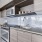 Spacious and well lit kitchen with wood floors and stainless steel appliances 